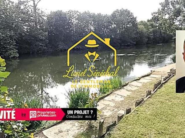 Terrain de loisirs de plus de 1 200 m2 avec un préau sur une dalle en dur, un abri de jardin et un accès direct à la rivière