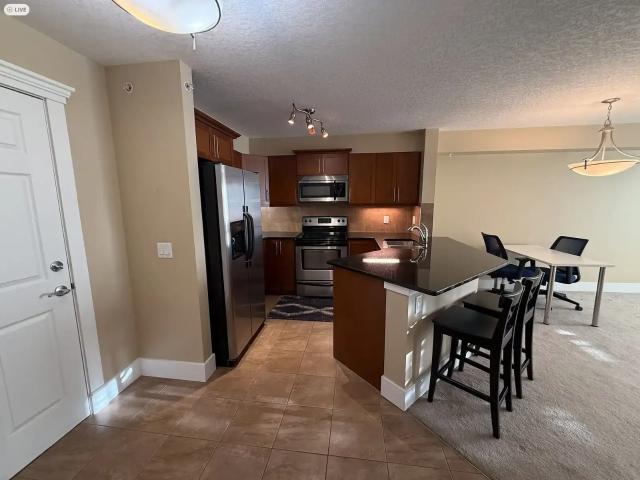 Top Floor 1 Bed + Den | Rocky Ridge Ranch Access | Heated Parking | Walk to LRT — 1 Bedroom+ Den Condo Unit