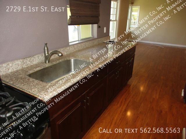 Upper REMODELED unit w/granite, hardwood, BALCONY & GARAGE! Onsite laundry & shared yard