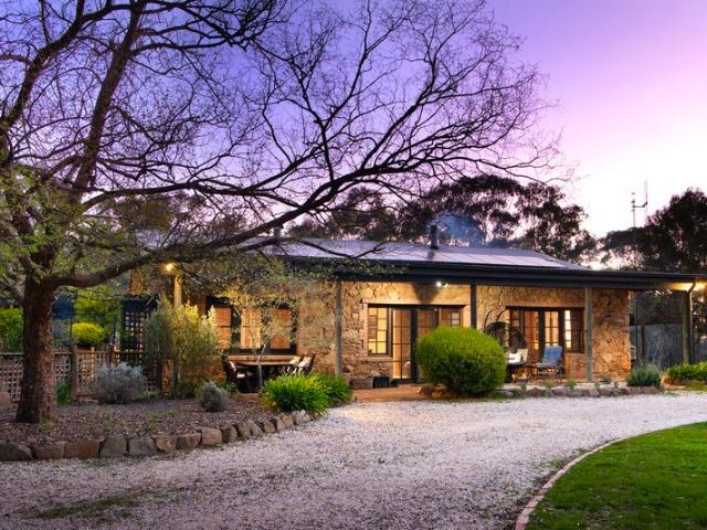 A Beautifully Crafted Stone Home with 4 acres and Serious Shedding