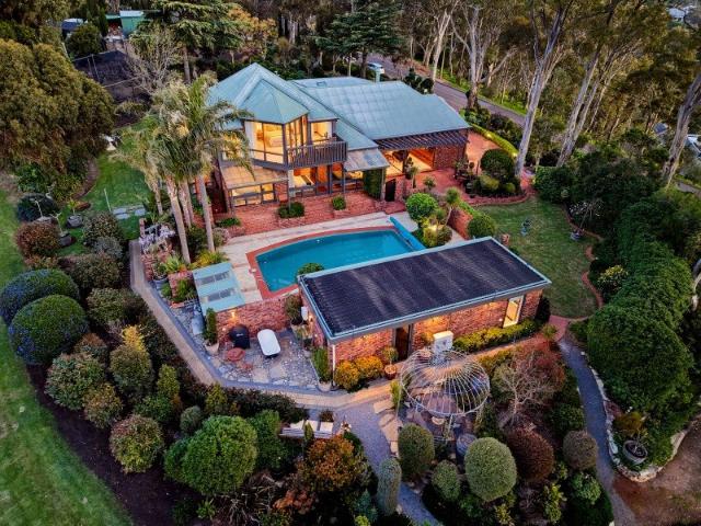 A private hillside retreat with sweeping city and coastal views on approximately 4475sqm landscaped gardens