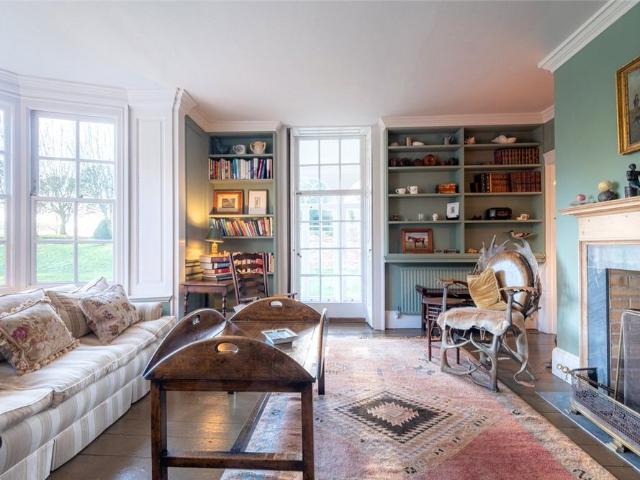 A substantial Grade II listed country residence with 7 to 9 bedrooms, exceptional gardens, and far reaching countryside views in a desirable village setting