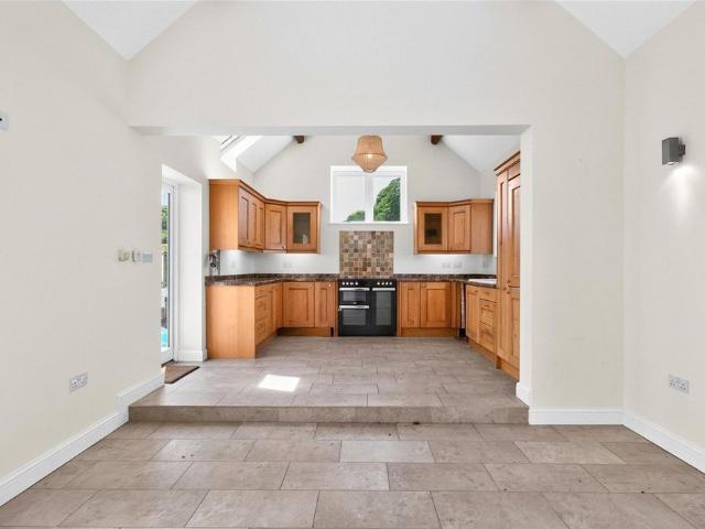A well presented four bedroom detached property with lawned gardens, a gravelled parking area accessed by electric gates and an outbuilding in Stafford
