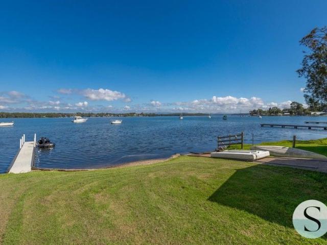 Absolute Waterfront Living, with All the Must Haves, Jetty, Slipway, Boat Shed, Garaging Galore, Half Tennis Court, Resort Pool & Architectural Home!