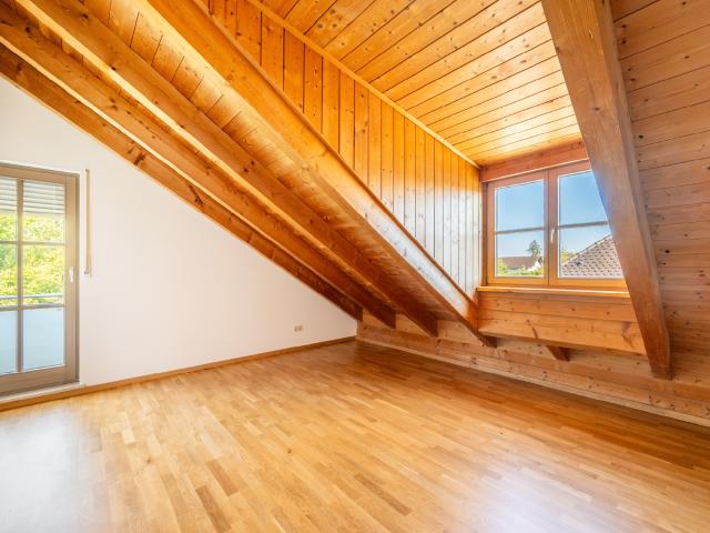 AIGNER Großzügige Dachgeschosswohnung mit stilvollen Holzdetails