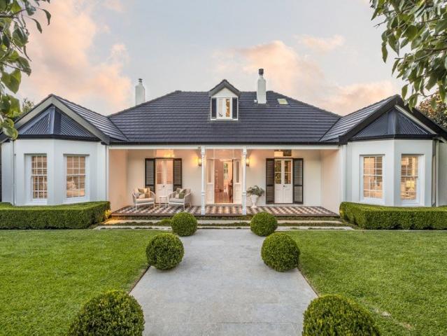 An impeccably transformed landmark residence exquisitely landscaped gardens with a pool and leafy northeast vistas