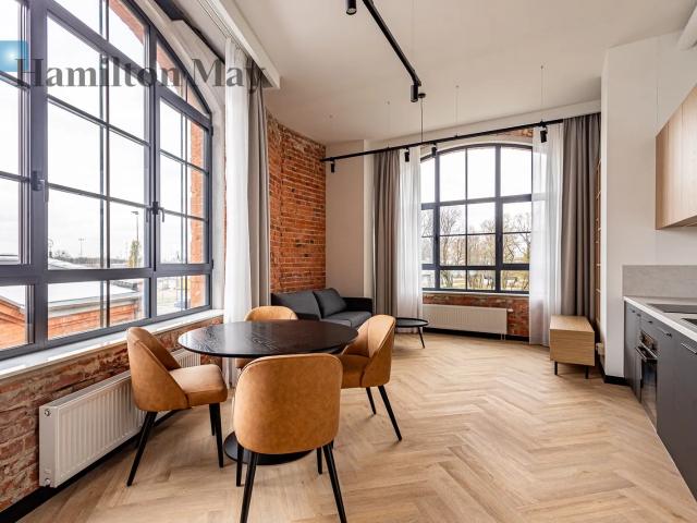 A three room loft with large, beautiful windows, located right next to the Szwedzka metro station