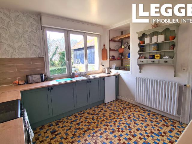 Cette charmante maison de style pavillon, comprenant trois chambres, dispose de plusieurs dépendances et est i