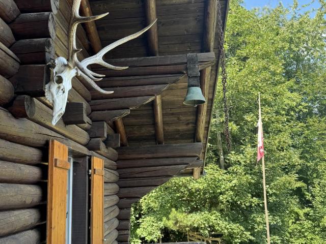 Chalet aus Fichtenstämmen in grüner Umgebung mit Blick auf die Rhôneebene