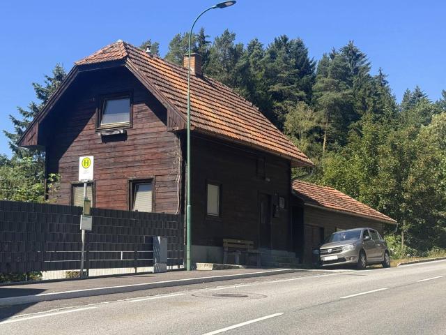 Charmantes Holzblockhaus in grüner Umgebung mit Nebengebäude