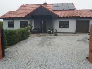 Dom z panelami fotowoltaicznymi i dużym tarasem