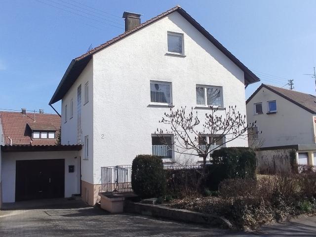 Ein Zweifamilienhaus mit Garten und großer Garage