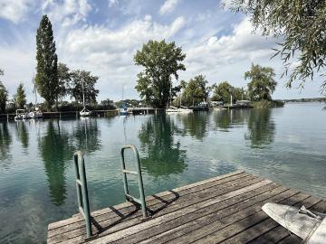 große UFERPAZRELLE mit privatem Badesteg am Neufelder See – Holzhaus mit Renovierungsbedarf beim Yachtclub auf Pachtgrund zu verkaufen