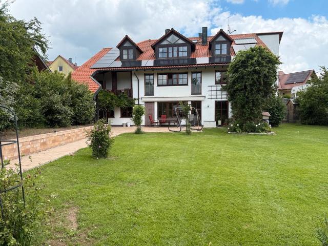 Mehrgenerationen Haus mit kleinem Bach hinter dem Haus und Wiese