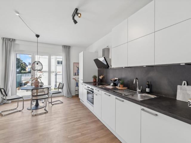 Moderne 3 Zimmer Wohnung: Stilvoller Neubau in attraktiver Lage mit Einbauküche und Balkon