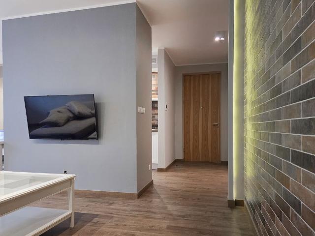 Salon z ceglaną ścianą apartament Maratońska Poznań