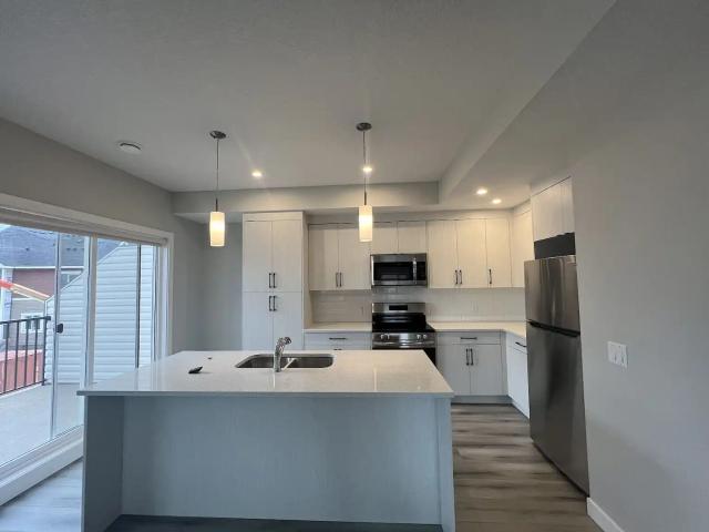 Spacious 3 Bed End Unit Townhouse with Attached Garage, Driveway & Guest Parking